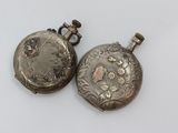 pair of antique silver pocket watches on a white background