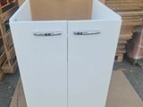 une armoire blanche à deux portes et un carton