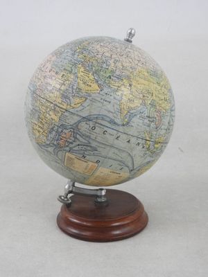 un petit globe terrestre posé sur un socle en bois et orné d'une carte