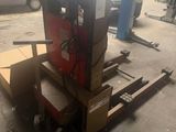 un gros plan d'un chariot élévateur chargé de cartons dans un garage