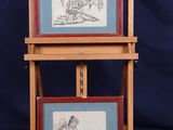 two framed pictures of a man and a woman on a stand