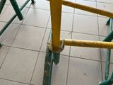 yellow and green scaffolding on the floor of a public transit station