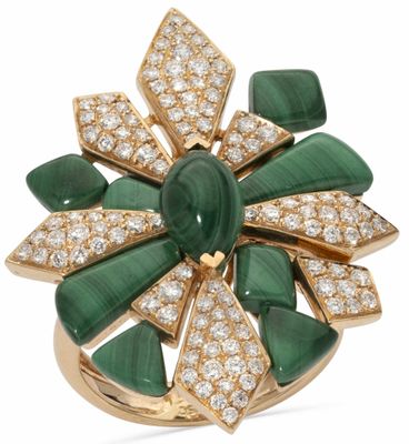 un gros plan d'une bague verte et blanche sertie de diamants