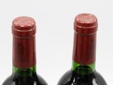 two bottles of wine sitting next to each other on a table