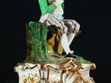 a figurine of a man sitting on top of a tree stump