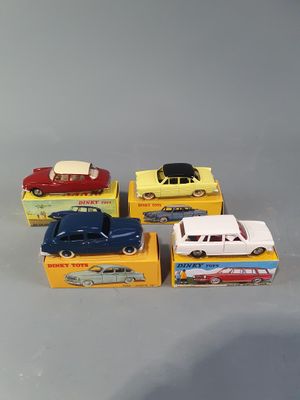 four toy cars are sitting in a box on a gray surface