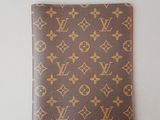 un portefeuille Louis Vuitton posé sur une surface blanche