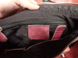a person holding a purse with a pink handle
