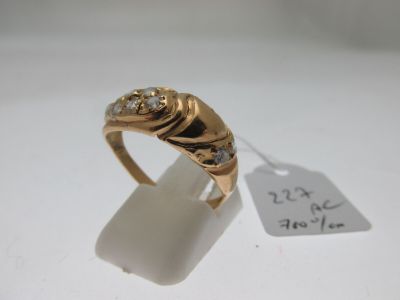 une image d'une bague en or avec des diamants sur une surface blanche