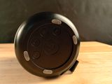 a black speaker sitting on top of a wooden table