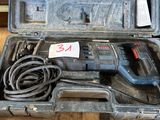 une boîte contenant une perceuse et un cordon, posée sur une table