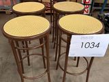 quatre tabourets en bois avec des assises en osier dans un magasin