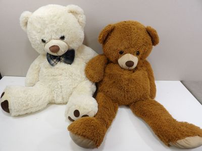 two teddy bears sitting next to each other on a table