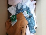 une boîte remplie de vêtements, avec un sac à main à l'intérieur