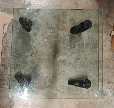 une table en verre équipée de roulettes dans une pièce