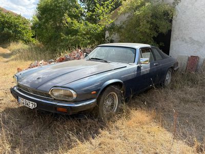 une voiture bleue garée devant un immeuble blanc