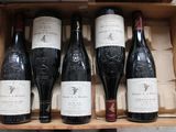 several bottles of wine are in a wooden box on a table