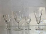 quatre verres à vin posés sur une étagère en verre dans une cuisine