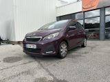 La petite voiture est garée devant un immeuble.