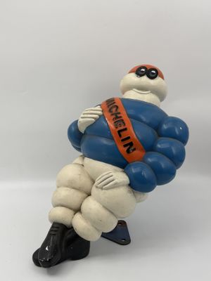 figurine of a man in a blue and white suit sitting on a white surface