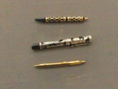 three pens that are sitting next to each other on a table