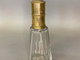 une image représentant une petite bouteille en verre avec un bouchon doré