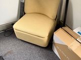 a chair that is next to a box on the floor