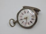 a silver pocket watch with roman numerals on it