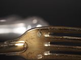 a gold fork and a silver spoon on a table