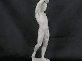 a white marble statue of a man holding a tennis racquet