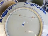a lot of blue and white plates and bowls on the table