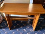 a small wooden table with a chair next to it