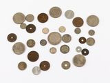 Plusieurs types de pièces de monnaie sont disposées en cercle sur une surface blanche.