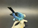 blue bird on a branch figurine on a black background
