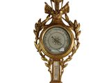 une horloge en or sur le mur avec un oiseau dessus
