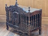 a wooden crib that is on the floor in a room