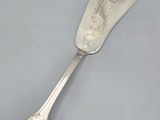 une cuillère en argent ornée d'un motif, posée sur une table