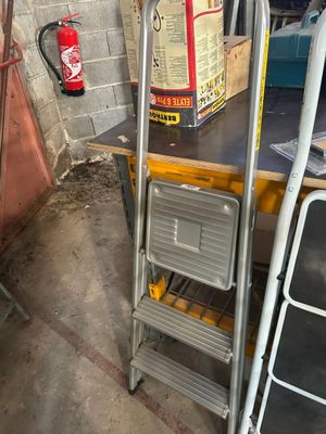 a ladder that is next to a table in a garage