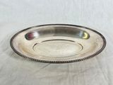 a close up of a silver plate on a white cloth