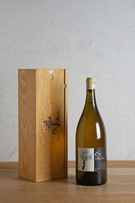 une bouteille de vin à côté d'une caisse en bois sur une table