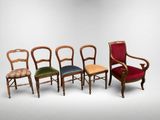 four chairs in different colors are lined up against a white wall