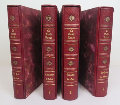 trois livres rouges sont alignés les uns à côté des autres sur une surface blanche