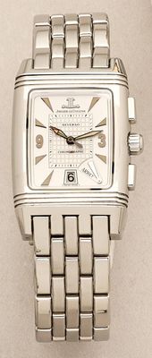 a close up of a silver watch on a white surface