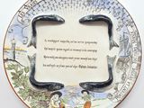 une assiette sur laquelle est inscrit un poème, posée sur une table
