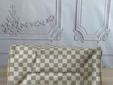 a checkered purse sitting on a wooden table next to a wall