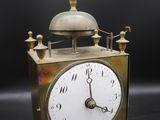 a small brass clock with a bell on top of it