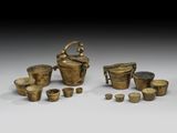 un ensemble d'objets en laiton, comprenant une bouilloire, des tasses et d'autres objets