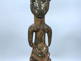 une statue représentant une femme avec un serpent sur le dos