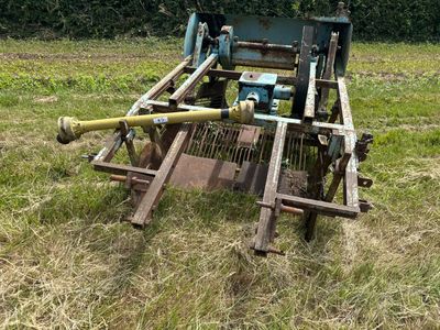 un tracteur qui se trouve dans l'herbe, avec un tuyau raccordé