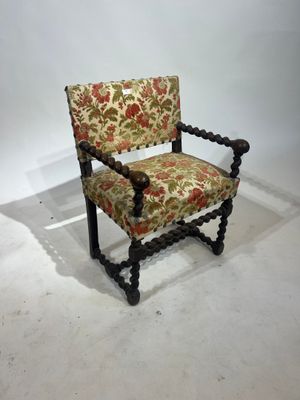 Une chaise à bras en bois tourné, elle pose sur quatre pieds…